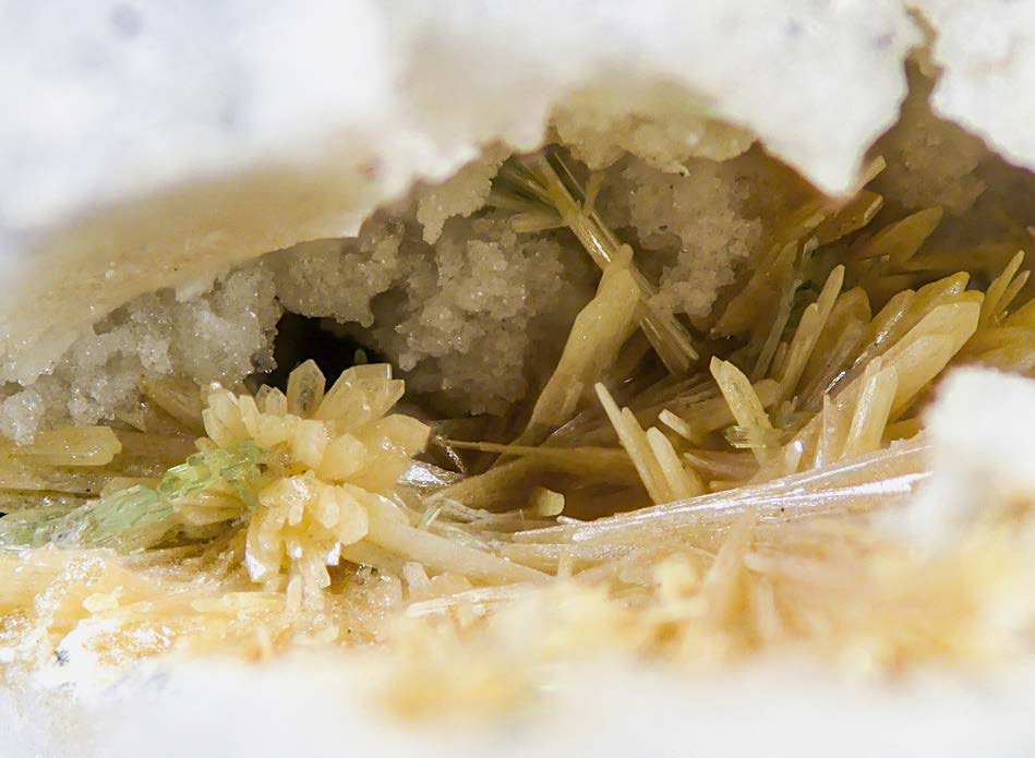 Figura 21. Grupo de cristales de paratelurita asociados con mandarinoita, en una geoda de cuarzo de 12 mm de ancho. Dique 2, Cerro del Cinto. Colección Ignacio Gaspar, foto Borja Sainz de Baranda.